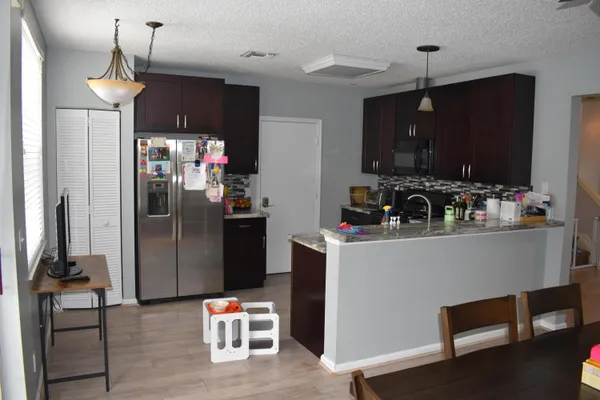 a kitchen with stainless steel appliances a refrigerator and a wooden floor