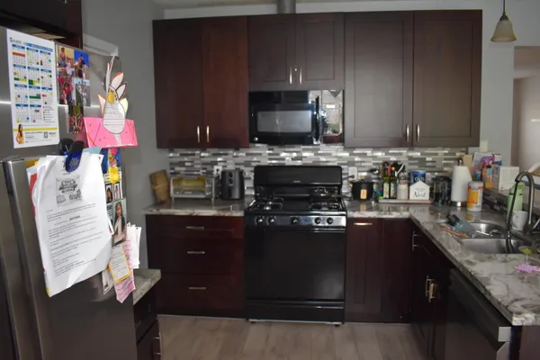 a kitchen with stainless steel appliances granite countertop a stove refrigerator and microwave