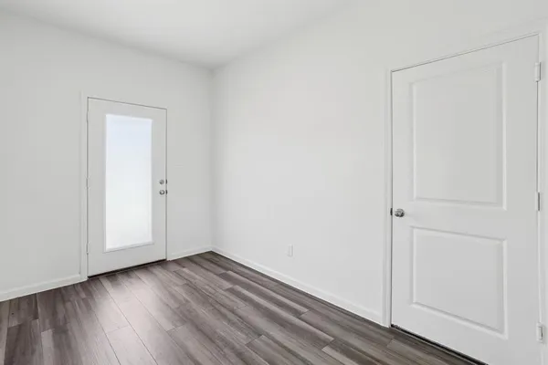 a view of an empty room with wooden floor