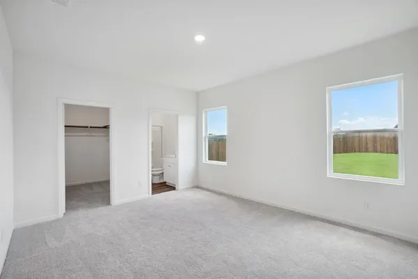 an empty room with a window and a dresser