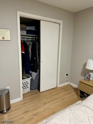 a bedroom with a bed and a wooden floor