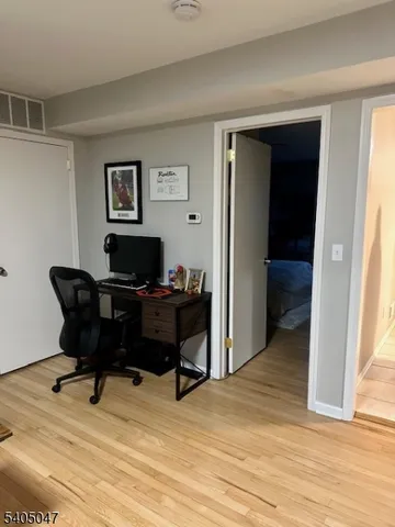 a view of a workspace with furniture and a window