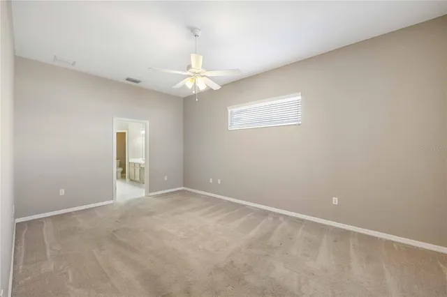 an empty room and chandelier fan