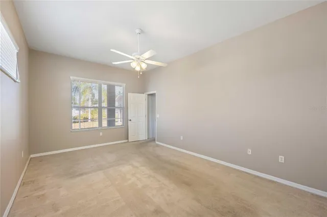 a spacious bathroom with a granite countertop sink a toilet a mirror and a vanity