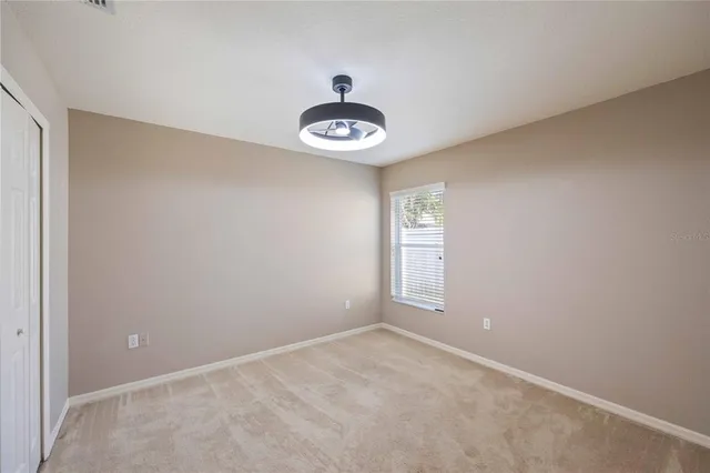 a bathroom with a granite countertop sink a toilet a mirror and a window