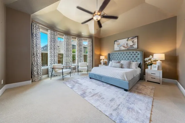 a bedroom with a bed couch and a large window