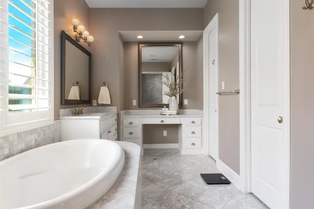a bathroom with a tub sink and mirror