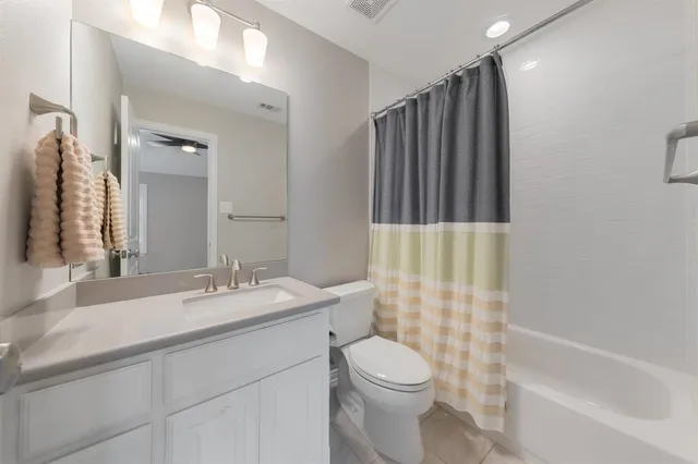 a bathroom with a sink a toilet a mirror a bathtub and shower