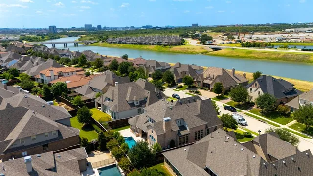 an aerial view of residential houses with outdoor space and lake view