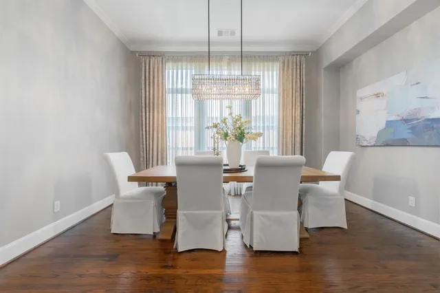 a dining room with furniture a chandelier and wooden floor