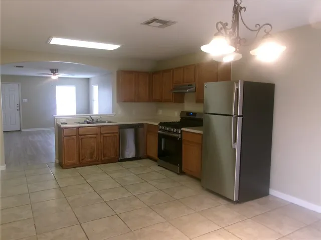 a kitchen with a cabinets a counter top space and stainless steel appliances