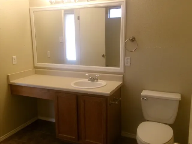 a bathroom with a sink mirror vanity and toilet