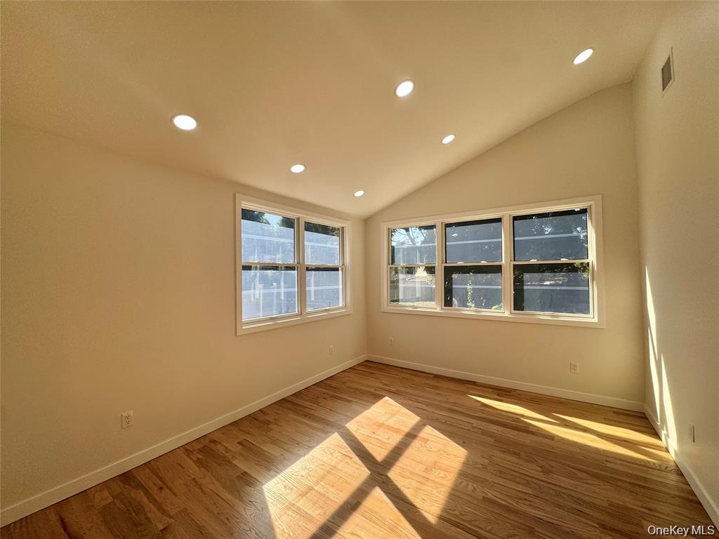 98 Steamboat Road Great Neck, NY 11024 - Photo 12 of 23 Bright corner room featuring multiple windows with natural light, recessed ceiling lighting, and warm wood-finish flooring throughout