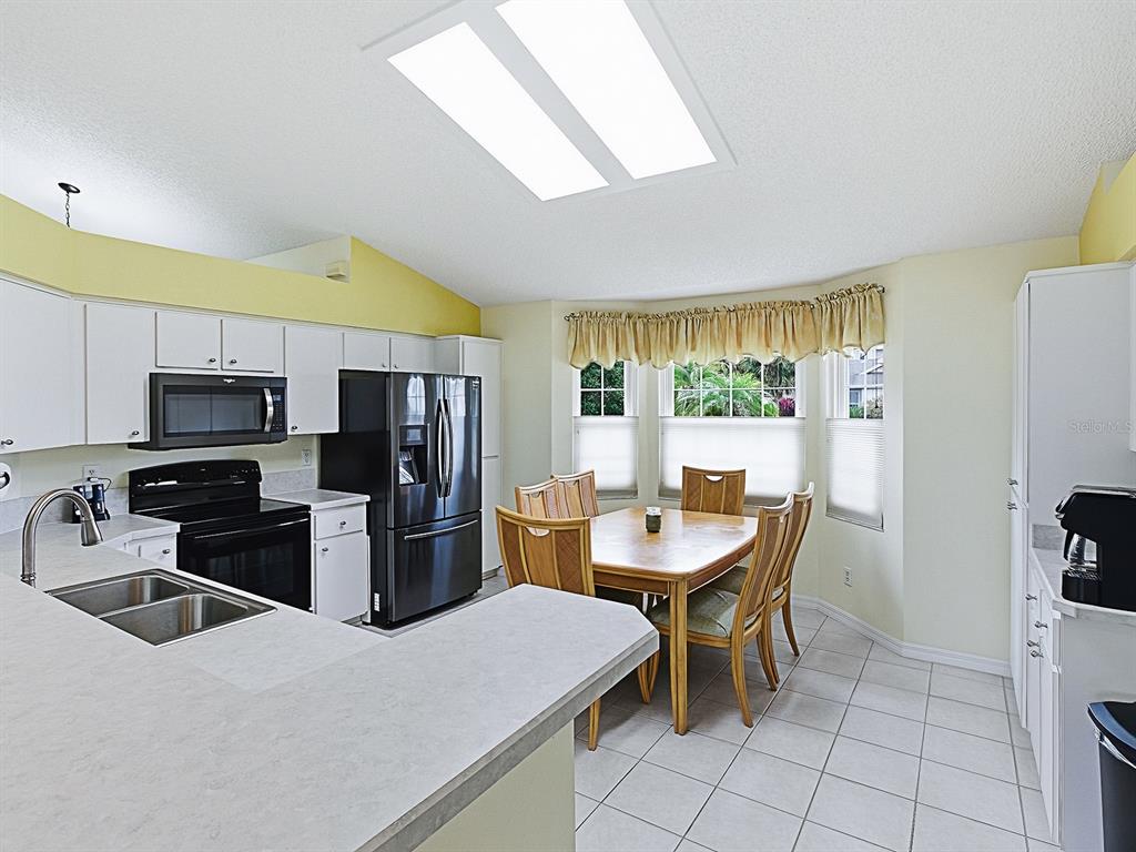 5588 Gulf Stream Street Tavares, FL 32778 - Photo 12 of 44 a kitchen with stainless steel appliances kitchen island granite countertop a sink a stove and refrigerator