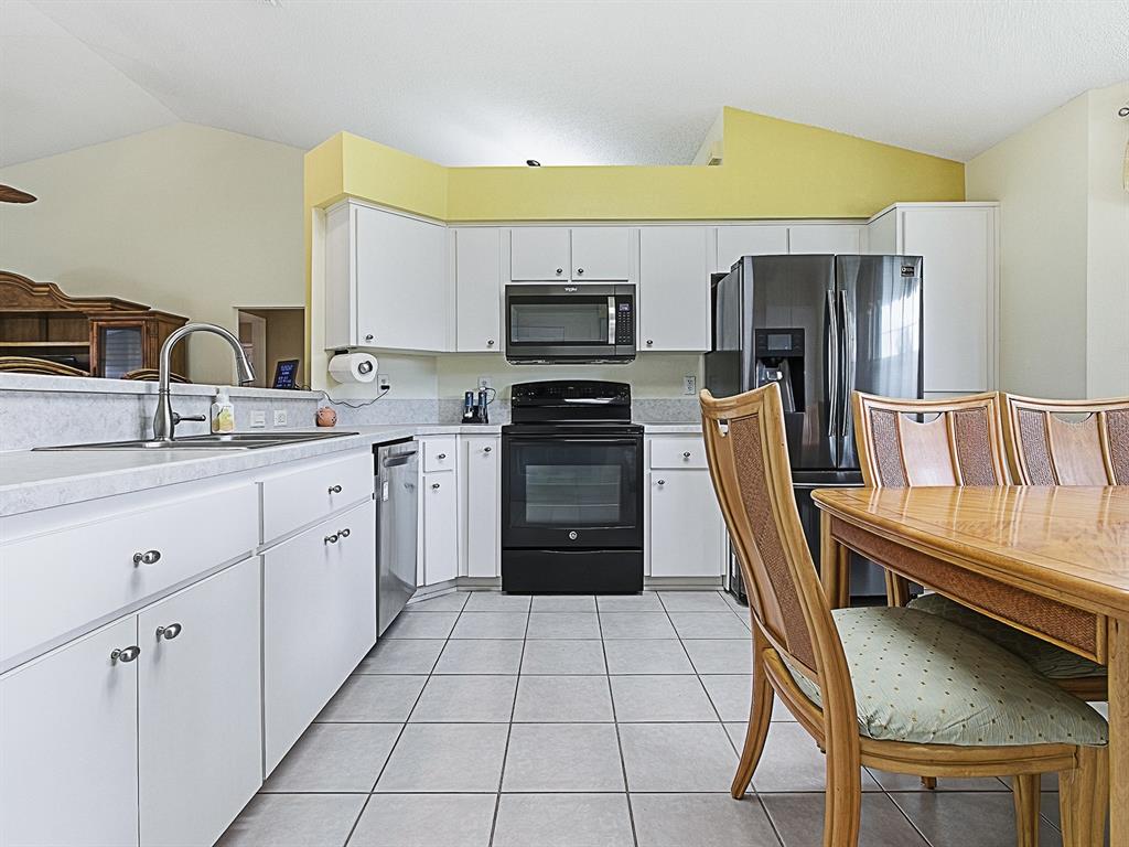 5588 Gulf Stream Street Tavares, FL 32778 - Photo 14 of 44 a kitchen with a refrigerator a stove top oven a sink and dishwasher