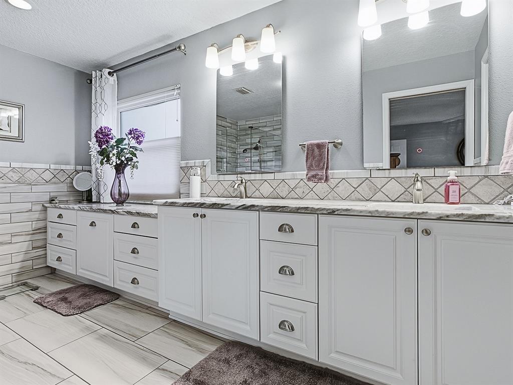 5588 Gulf Stream Street Tavares, FL 32778 - Photo 20 of 44 a bathroom with a sink vanity granite and a mirror