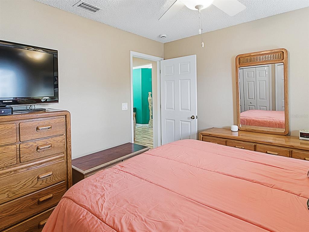 5588 Gulf Stream Street Tavares, FL 32778 - Photo 26 of 44 a bedroom with a bed and a flat screen tv