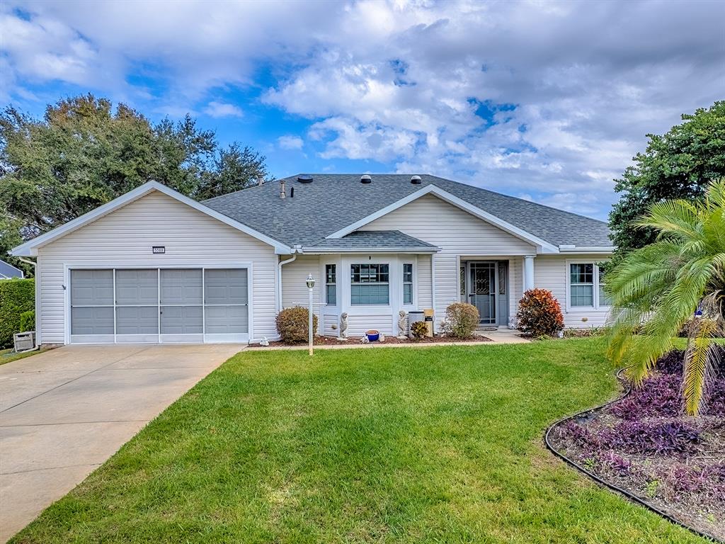 5588 Gulf Stream Street Tavares, FL 32778 - Photo 3 of 44 a front view of a house with a garden and trees