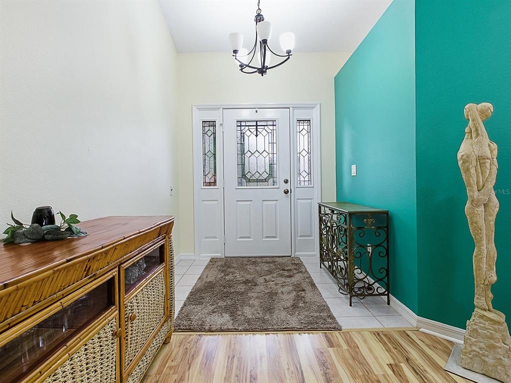 5588 Gulf Stream Street Tavares, FL 32778 - Photo 6 of 44 a view of a hallway with entryway wooden floor and front door