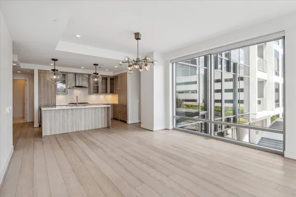 a view of an empty room with wooden floor and a floor to ceiling window