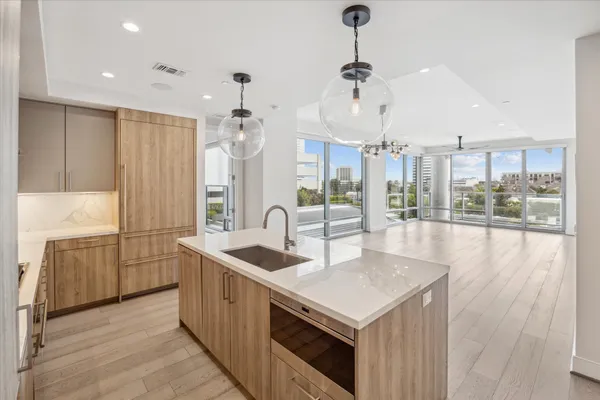 a large kitchen with kitchen island a large window and stainless steel appliances