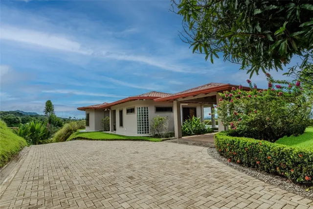 a front view of a house with a garden and trees