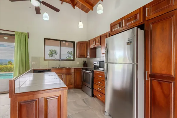 a kitchen with stainless steel appliances granite countertop a refrigerator a stove and a sink with wooden floor