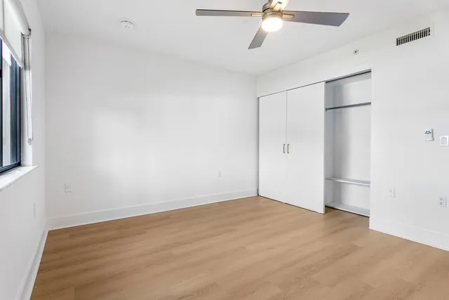 a view of an empty room with glass door and a window