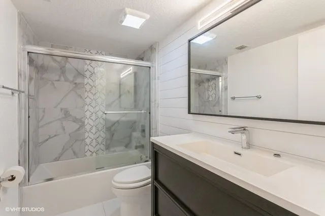 a bathroom with a sink a toilet and shower