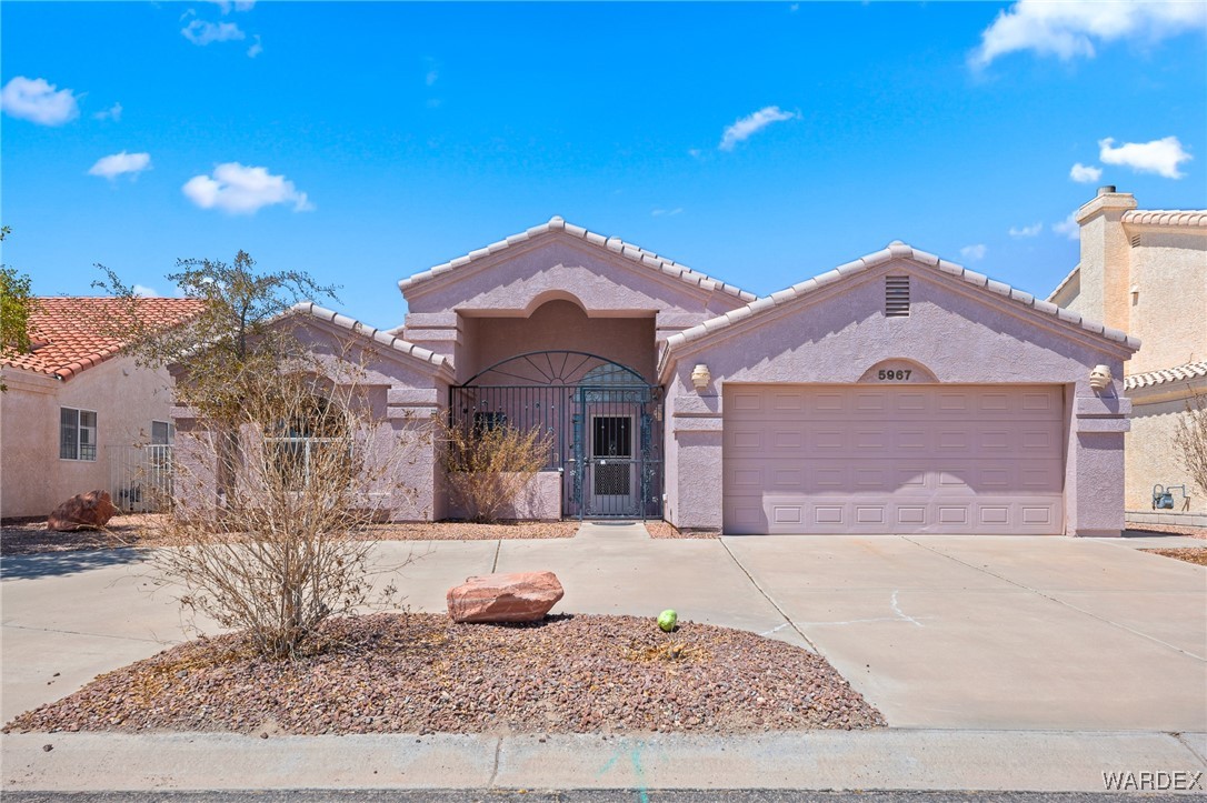 5967 Mountain View Road Fort Mohave, AZ 86426 - Photo 1 of 18 a front view of a house with a yard