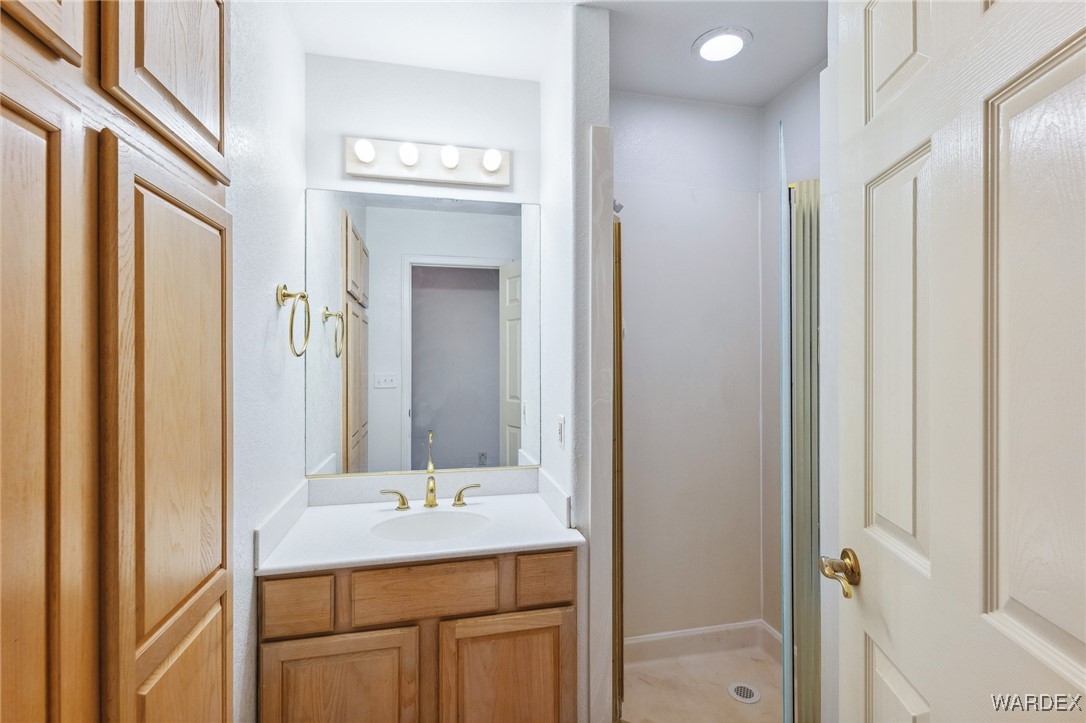5967 Mountain View Road Fort Mohave, AZ 86426 - Photo 9 of 18 a bathroom with a granite countertop sink a mirror and a shower