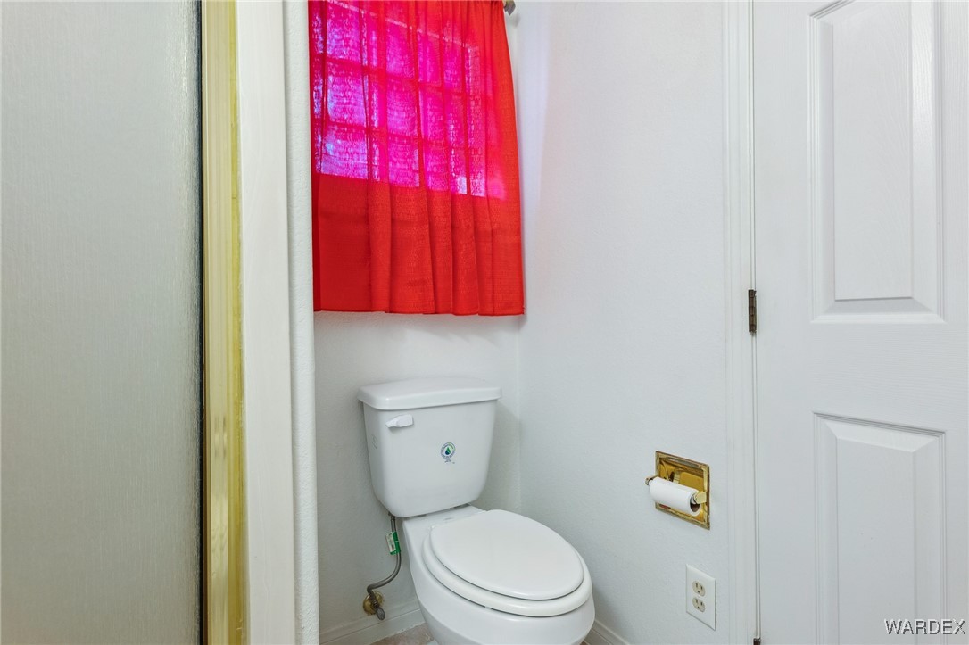 5967 Mountain View Road Fort Mohave, AZ 86426 - Photo 10 of 18 a white toilet sitting next to a bathroom sink and vanity