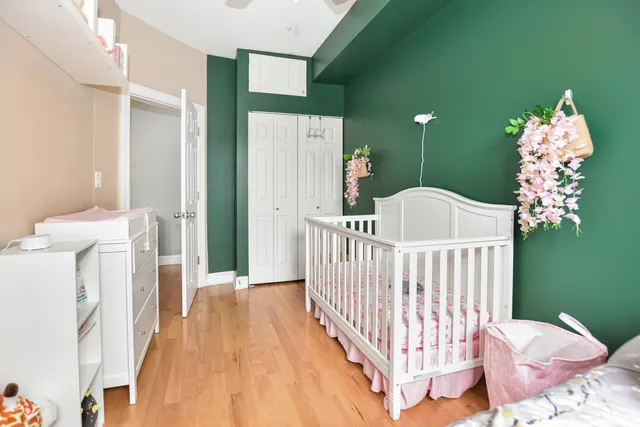 a view of a bedroom with a bed and wooden floor
