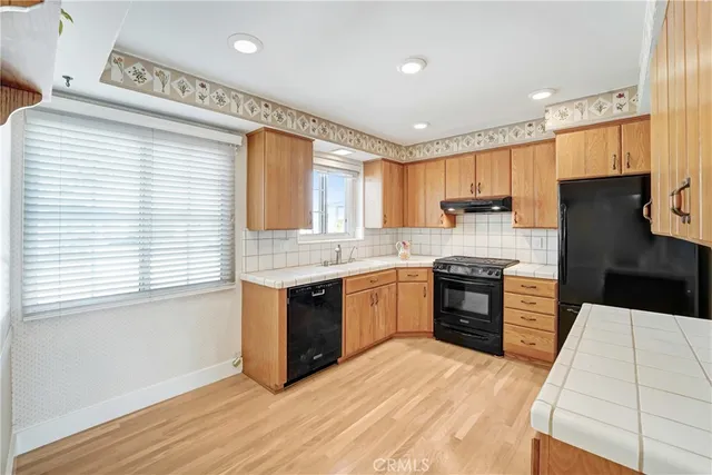 a kitchen with granite countertop a refrigerator stove top oven and sink