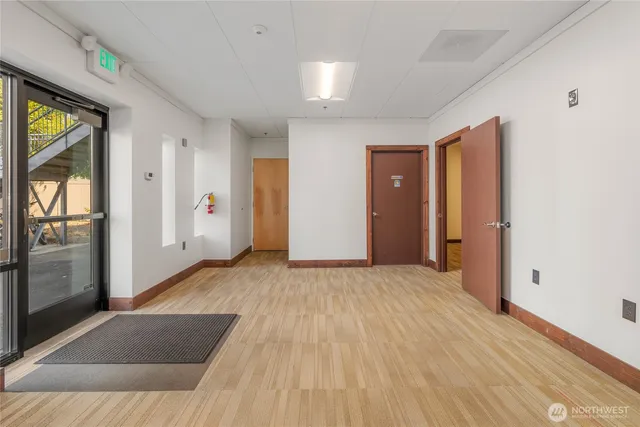 a view of a livingroom with wooden floor and a refrigerator
