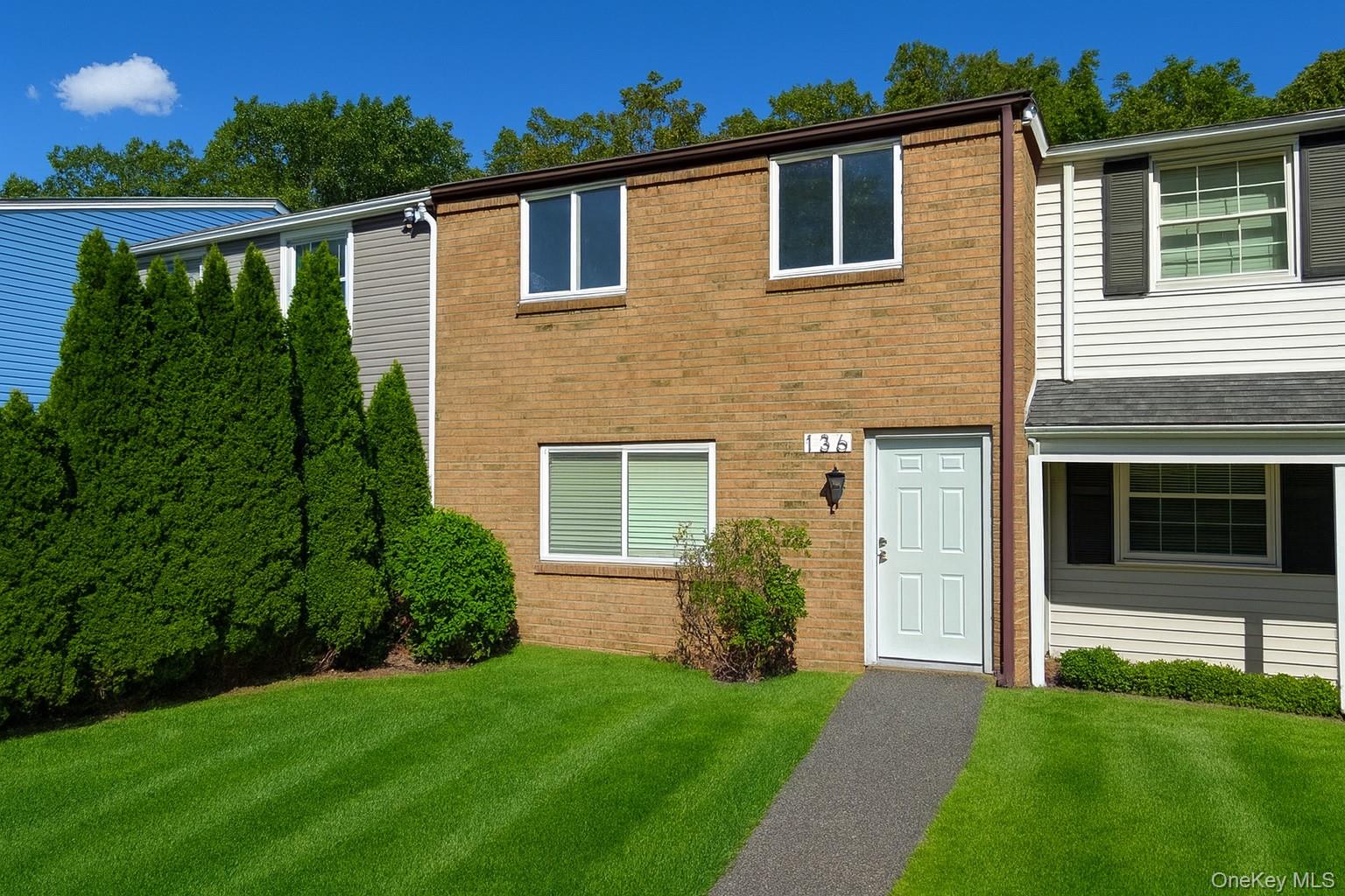 View of front of property with brick siding and a front yard