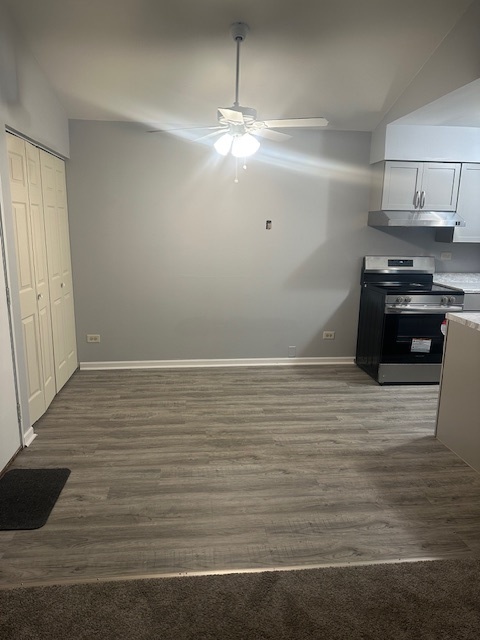 651 South Virginia Road, Unit 326 Crystal Lake, IL 60014 - Photo 4 of 9 a room with wooden floor and white cabinets