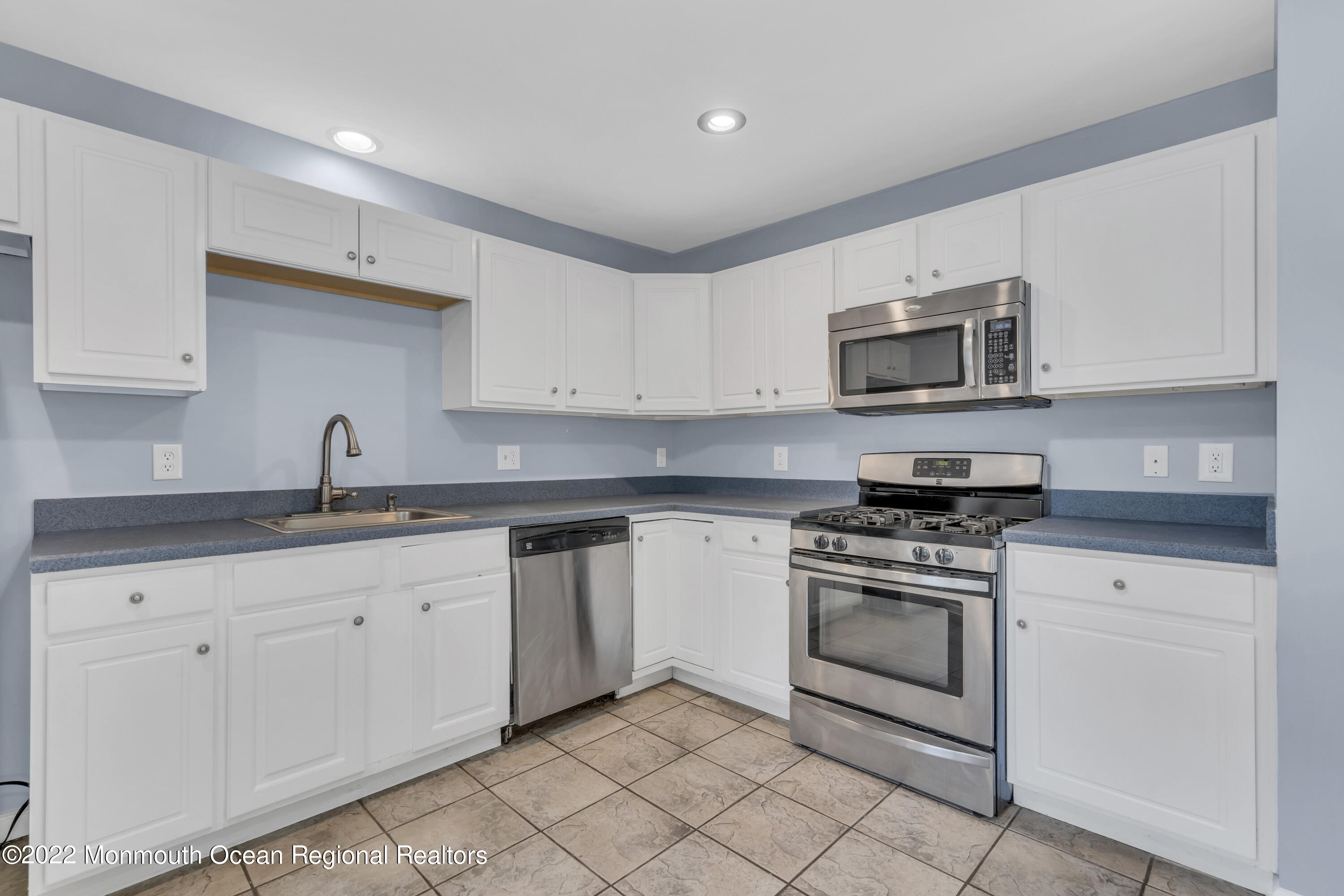 145 Gunwale Road Manahawkin, NJ 08050 - Photo 16 of 44 a kitchen with granite countertop white cabinets stainless steel appliances and a sink