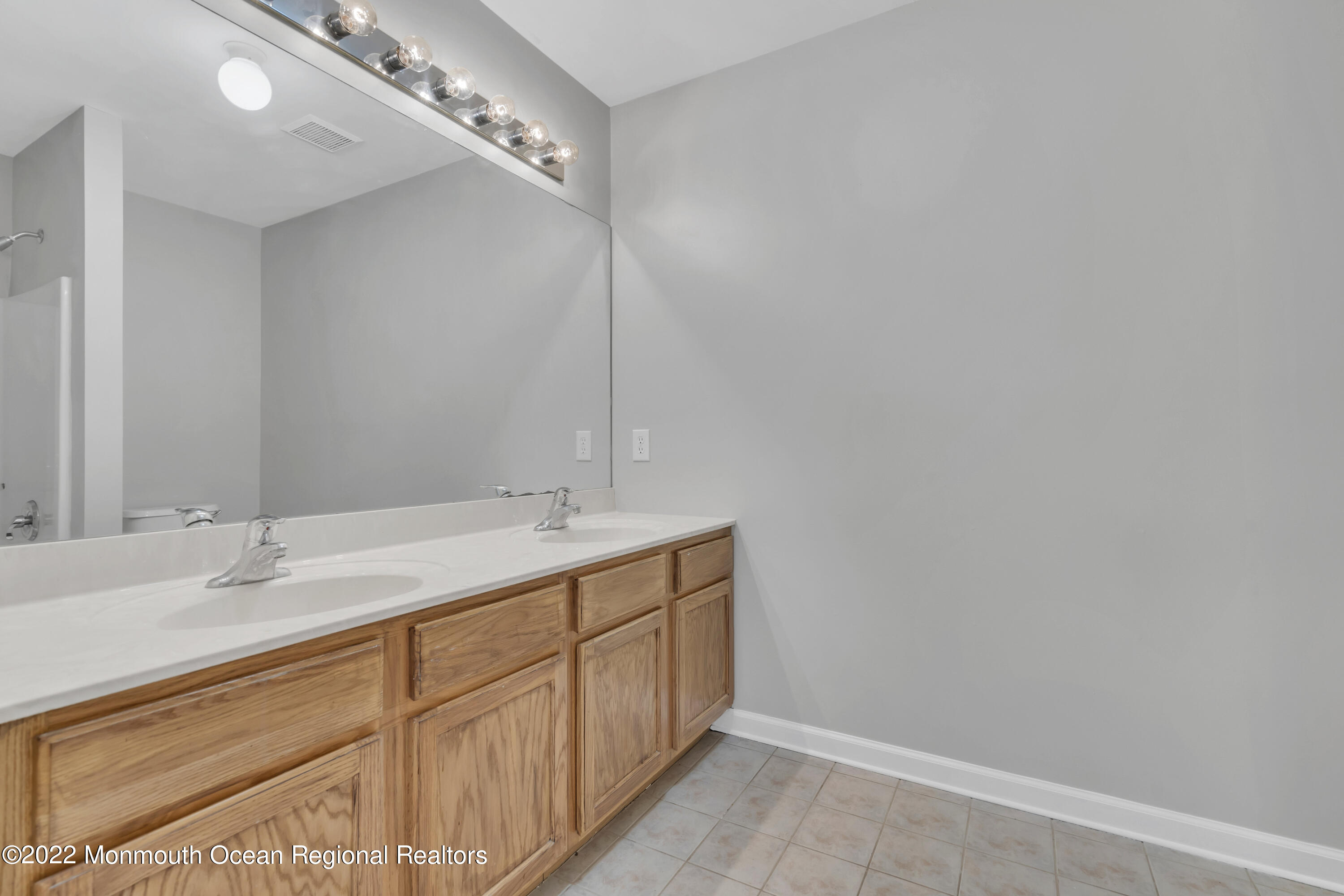 145 Gunwale Road Manahawkin, NJ 08050 - Photo 24 of 44 a bathroom with a double vanity sink and a mirror