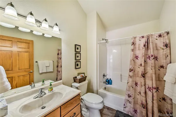 a living room with furniture a ceiling fan and a flat screen tv