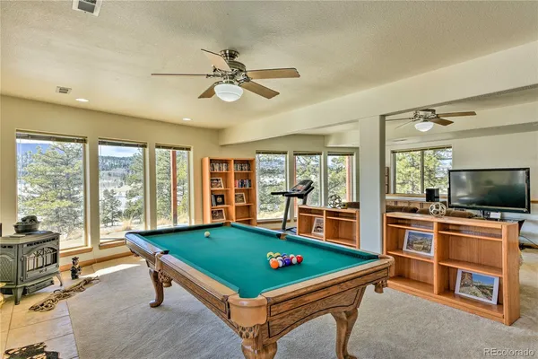 a room with pool table and windows