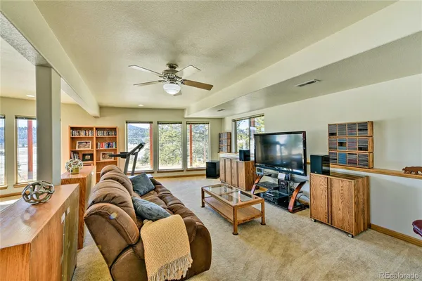 a living room with furniture a flat screen tv and a large window