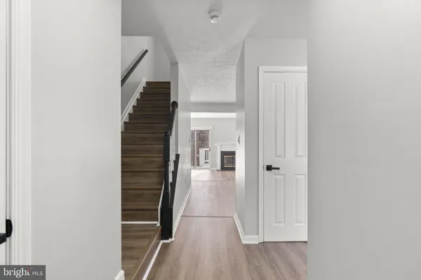 a view of a hallway with wooden floor and staircase