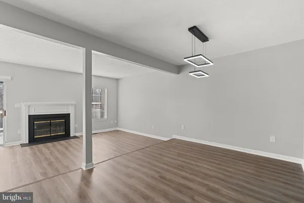 a view of empty room with wooden floor and fireplace