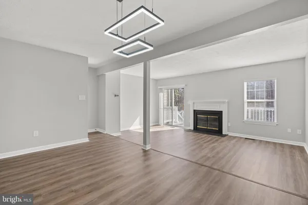 a view of empty room with wooden floor fireplace and windows