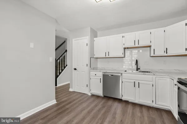 a kitchen with granite countertop white cabinets and white appliances