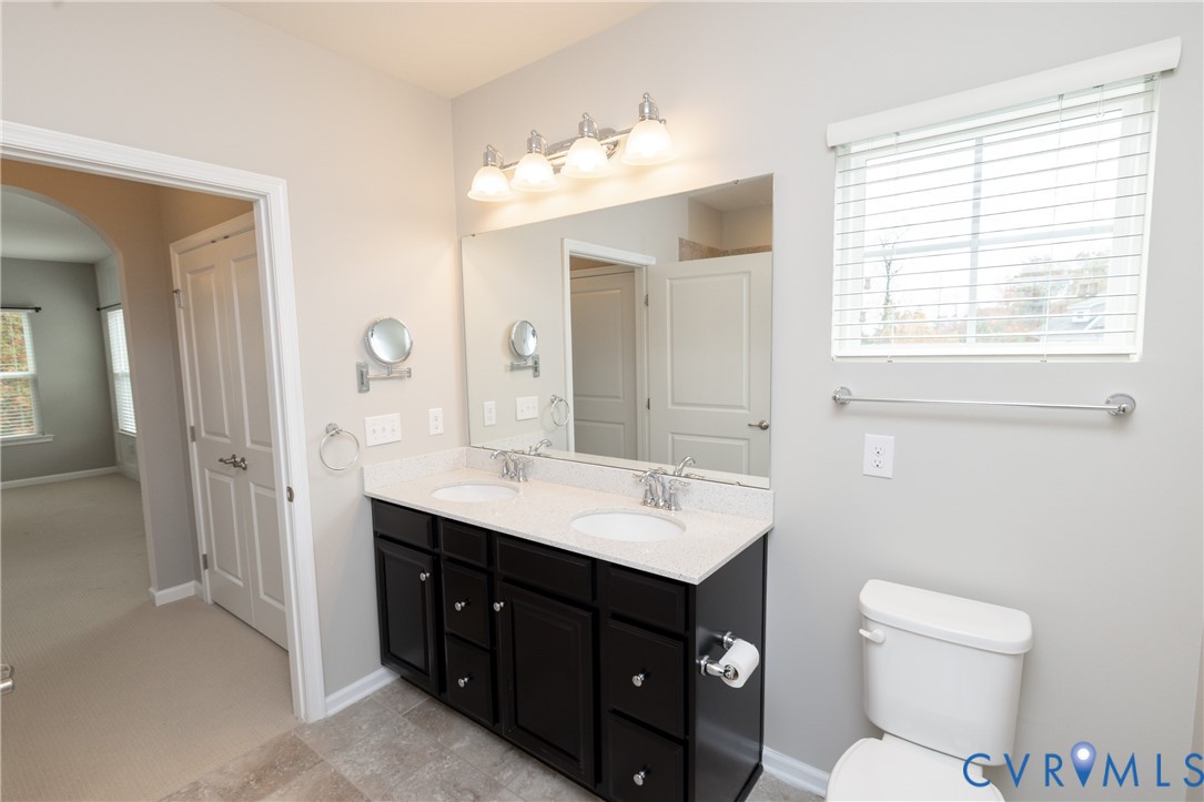 1111 Briars Court, Unit 303 Midlothian, VA 23114 - Photo 20 of 41 a bathroom with a toilet a sink a large mirror and vanity