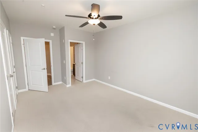 an empty room with closet and a chandelier fan