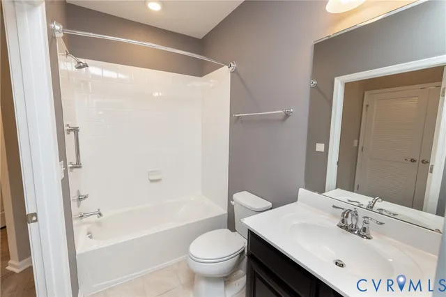 a bathroom with a bathtub shower sink mirror vanity and toilet
