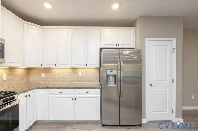a kitchen with refrigerator a stove and cabinets